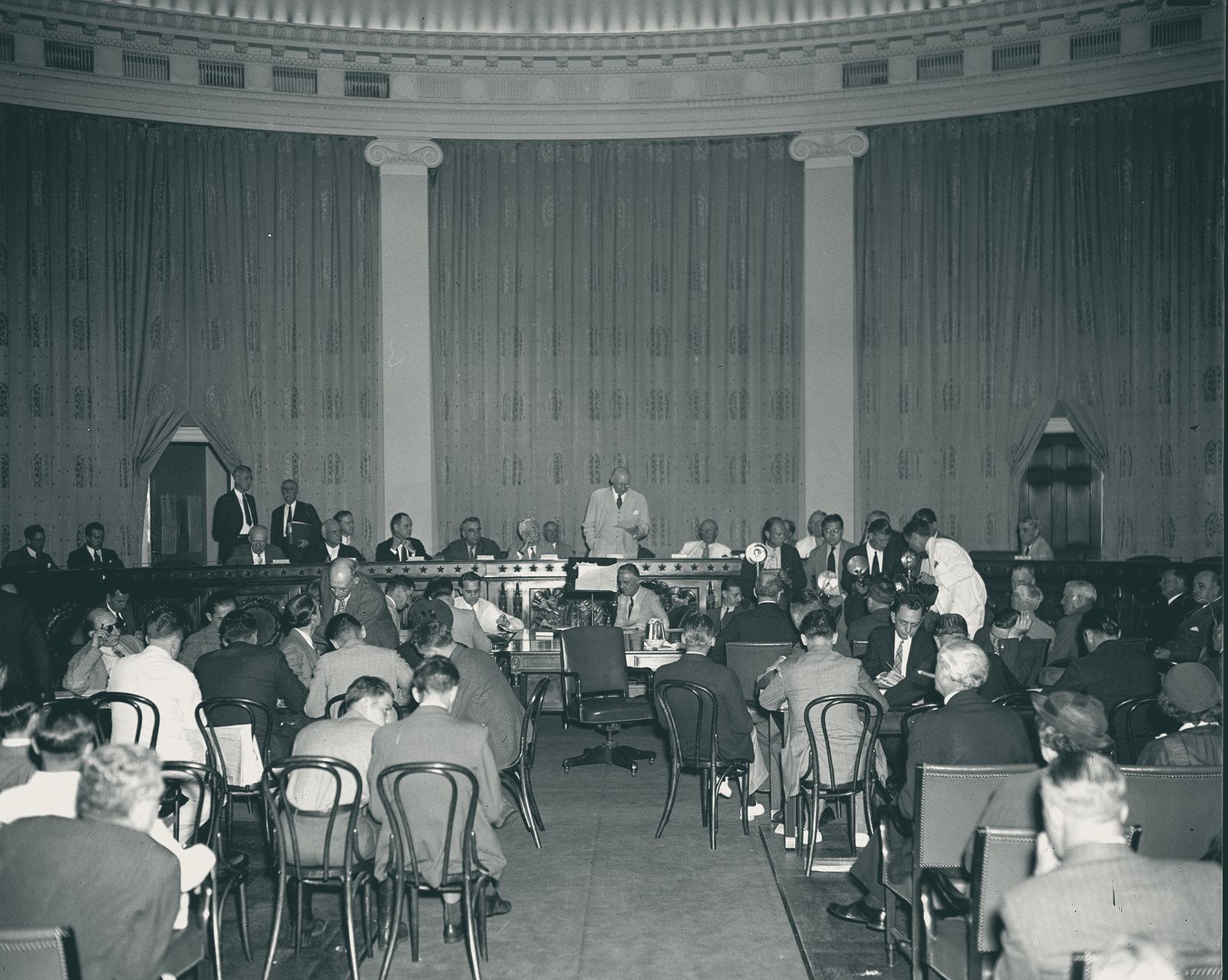 A congressional committee hearing, with members on the dais and witnesses and reporters at tables